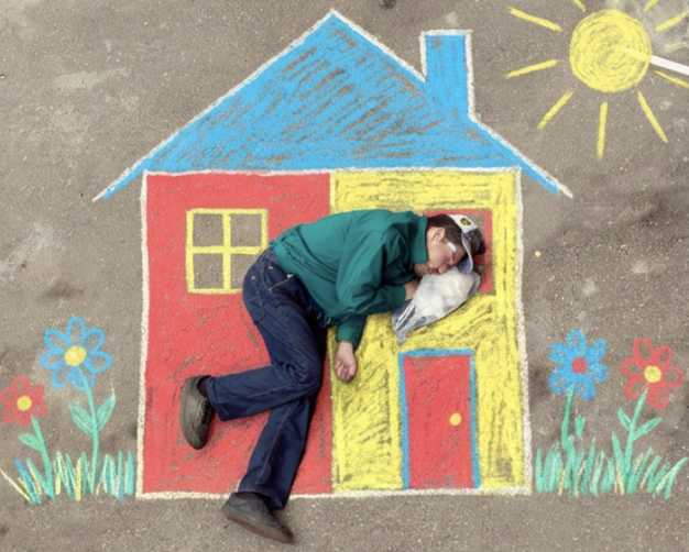 Chalk drawing of a colorful house with a person resting inside