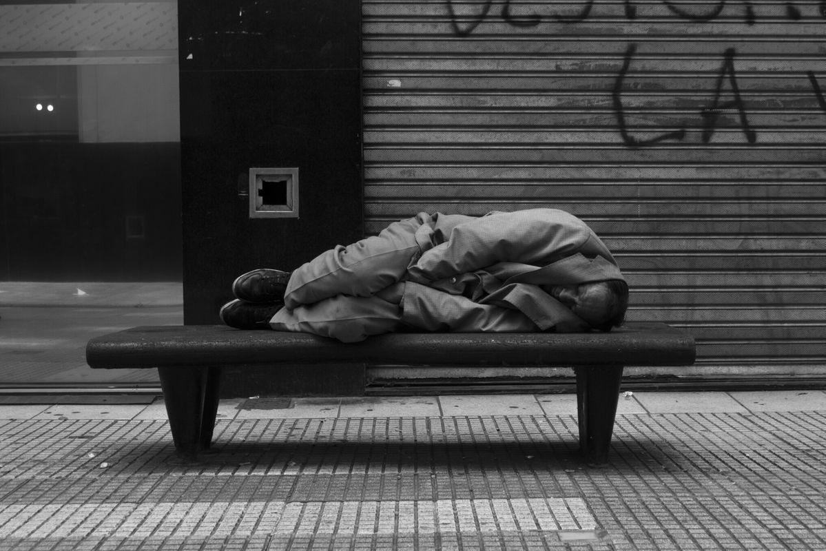 A person resting on a city bench